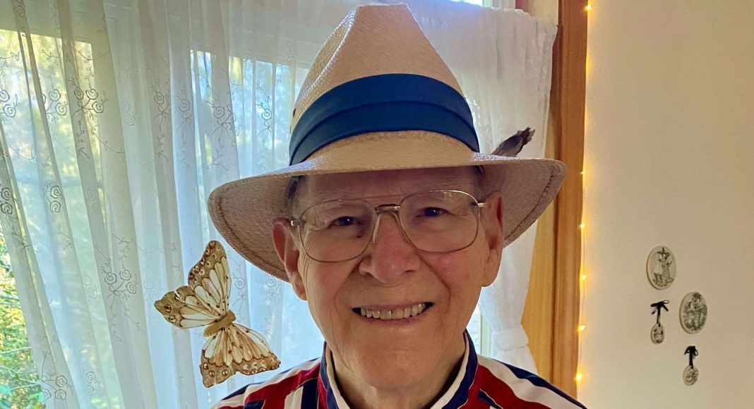 rogersweetheman Smiling elderly man in a striped red, white, and blue shirt wearing a straw hat with a blue band; a butterfly rests near his shoulder.