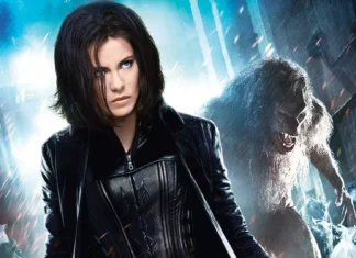 Woman with short dark hair in a black leather jacket, standing in a stormy icy landscape with a snarling white wolf behind her.