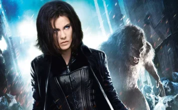 Woman with short dark hair in a black leather jacket, standing in a stormy icy landscape with a snarling white wolf behind her.