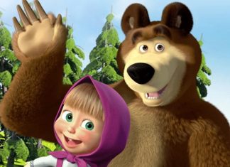 Brown bear and a smiling girl in a purple hood wave hello together in a bright forest setting
