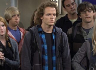 Ator de ‘How I Met Your Mother’ é CONDENADO por tentativa de homicídio Group of young adults standing indoors, looking ahead with neutral expressions; center man with curly hair in a blue plaid shirt.