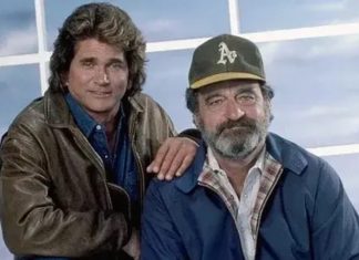 Two men in casual jackets posing together, one with a brown leather jacket and the other wearing a cap, hand on the other's shoulder.