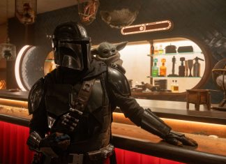 Mandalorian in black armor at a bar with Grogu perched on his shoulder, dim sci‑fi tavern setting.