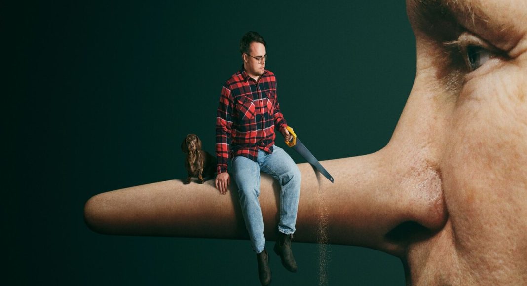 Surreal scene: a man in a red plaid shirt sits on a giant human nose holding a handsaw, with a small dog beside him against a dark green background.
