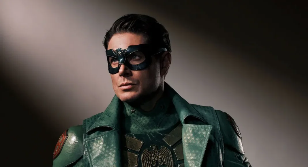 Vought-rising-soldier-boy Man in a green armored superhero costume and mask, posing with a serious expression, looking off to the side.