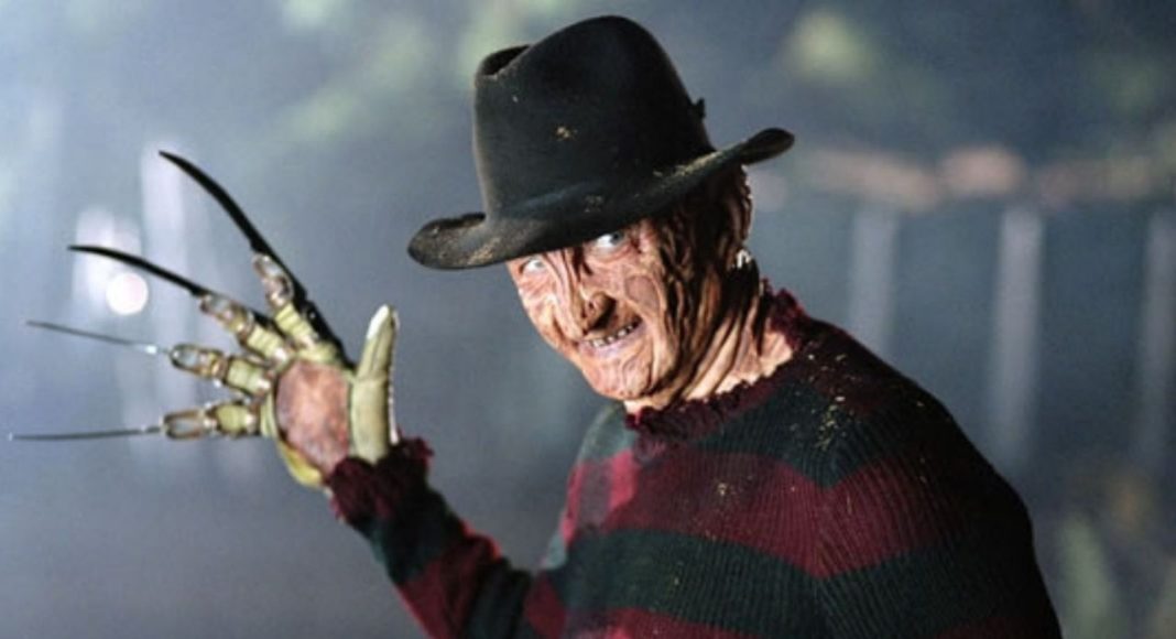 Freddy Krueger wearing a fedora and striped sweater, glove with blades raised toward the camera.