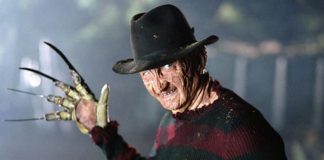 Freddy Krueger wearing a fedora and striped sweater, glove with blades raised toward the camera.