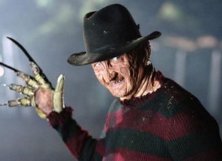 Freddy Krueger wearing a fedora and striped sweater, glove with blades raised toward the camera.