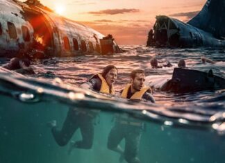 People wearing life jackets swim in the ocean beside a sunken airplane wreck at sunset, with smoke and flames in the background on the horizon.