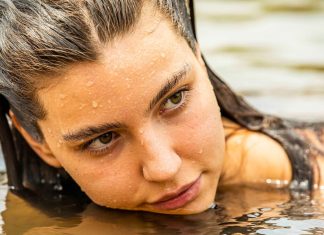 Alanis Guillen, atriz de ‘Pantanal’ e ‘Três Graças’, obtém medida PROTETIVA na Justiça contra ex-namorada Close-up of a woman with wet hair resting her chin on water, gazing to the side in outdoor water.