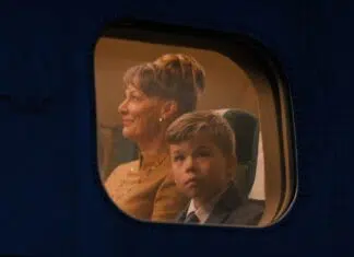 Crítica | Em ‘Aventura nas Alturas’, John Travolta transforma suas memórias em poesia cinematográfica (Cannes 2026) Woman with short hair and a young boy in a suit seated by an airplane window, illuminated by cabin light, looking ahead.