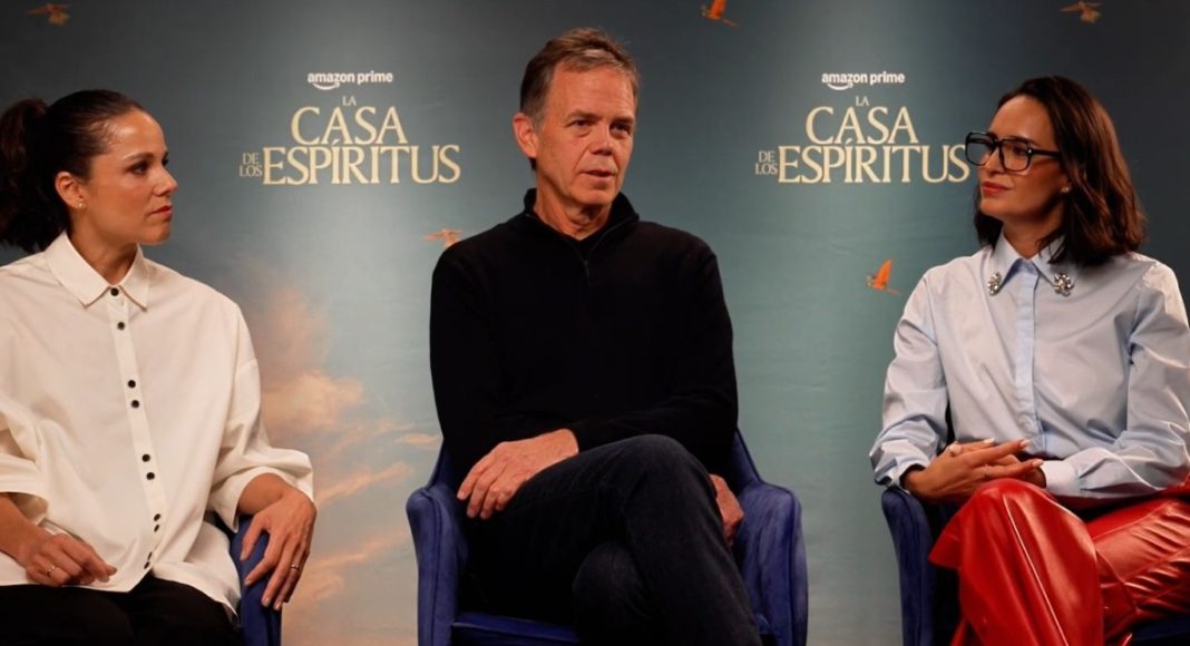 Three panelists seated on stage during a discussion at a La Casa de los Espíritus event. backdrop shows the show's title.