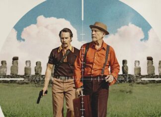 Two men stand side by side in a field, seen through a crosshair scope, one holding a pistol and the other a briefcase.
