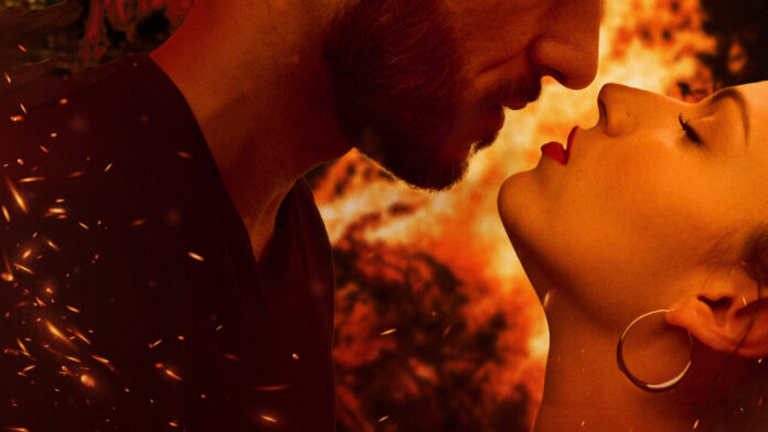Close-up of a couple about to kiss, warm orange light and embers floating around.