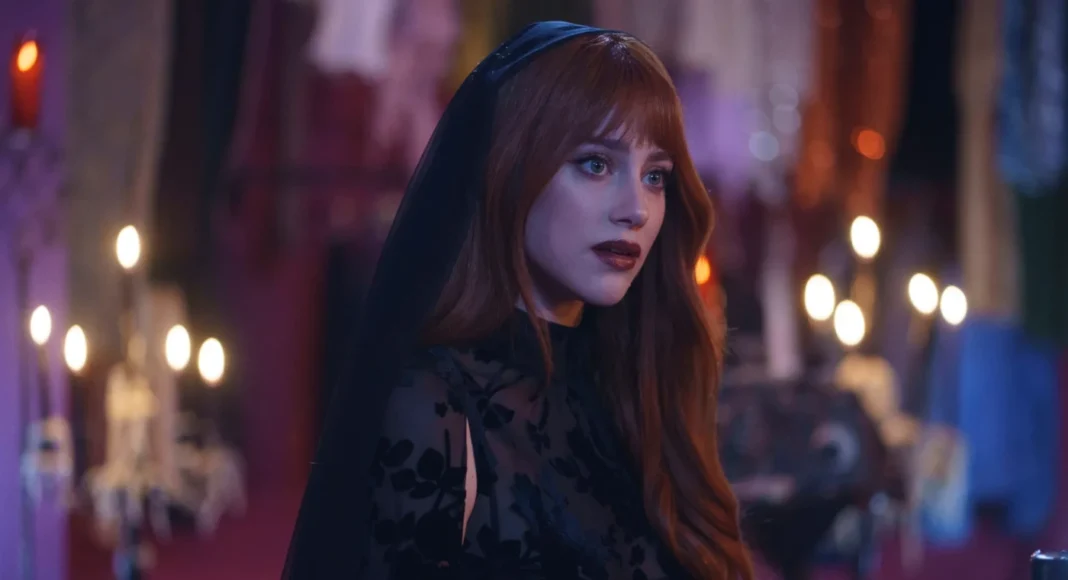 forbidden-fruits Woman with long red hair in a sheer black lace dress and veil, in a dim purple-lit venue.