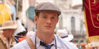 Young man in a gray flat cap, checkered shirt, and tie at a crowded street festival