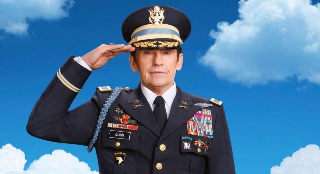 Senior military officer in dress uniform saluting against a blue sky in the background.