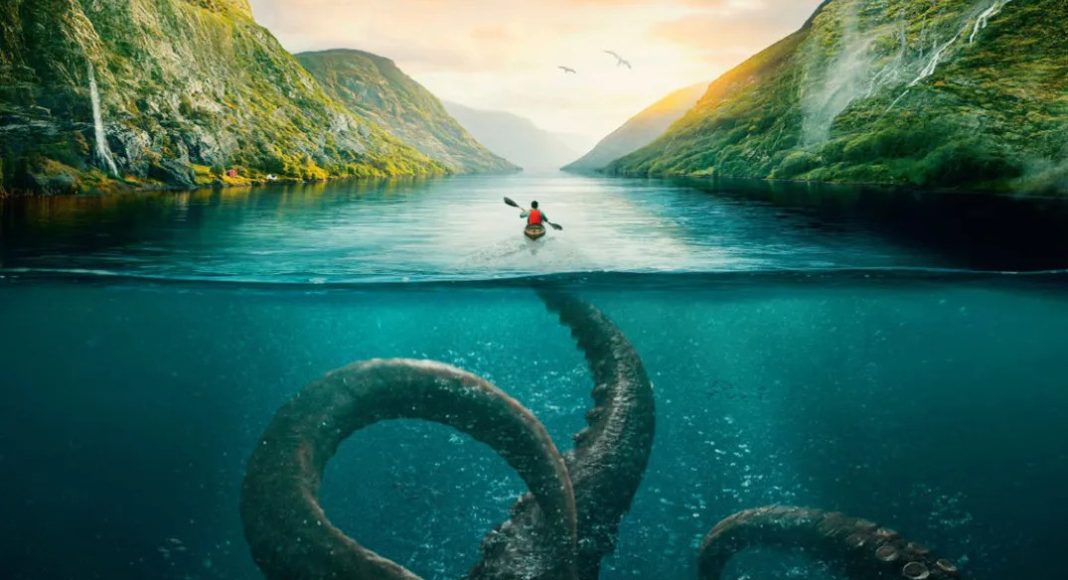 Kayaker paddling on a river between green mountains, with giant tentacles visible beneath the turquoise water.