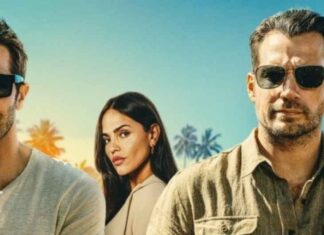 Crítica | Henry Cavill e Jake Gyllenhaal estrelam o divertido thriller de ação ‘Na Zona Cinzenta’ Three adults in casual clothes wearing sunglasses pose outdoors at a sunny tropical location with palm trees in the background.