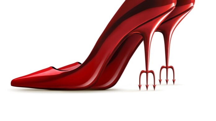 Red patent leather high-heeled shoe with forked, trident-like heels.