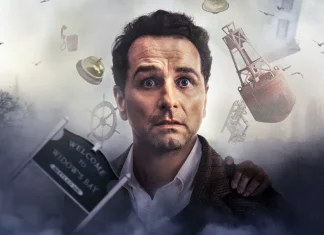 Creative Arts Emmy Awards 2026 | ‘O Segredo de Widow’s Bay’ é a grande VITORIOSA da premiação; Confira a lista! Man with a shocked expression amid floating objects in a smoky, surreal scene; sign reads 'Welcome to Widow's Bay' (film poster vibe).