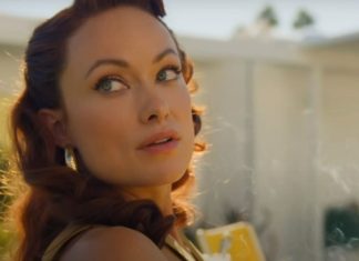 Olivia Wilde fala sobre rumores de DISCUSSÕES acaloradas com Florence Pugh no set de ‘Não Se Preocupe, Querida’ Close-up of a woman with wavy red hair looking over her shoulder in warm sunlight outdoors, wearing earrings.
