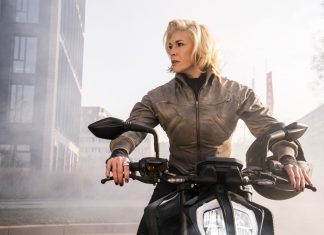 Octavia Spencer e Hannah Waddingham são ‘Parceiras no Crime’ nas cenas INÉDITAS da comédia; Confira! Woman in a brown jacket sits on a black motorcycle in an urban area, looking to the side with a helmet resting on the right handlebar.