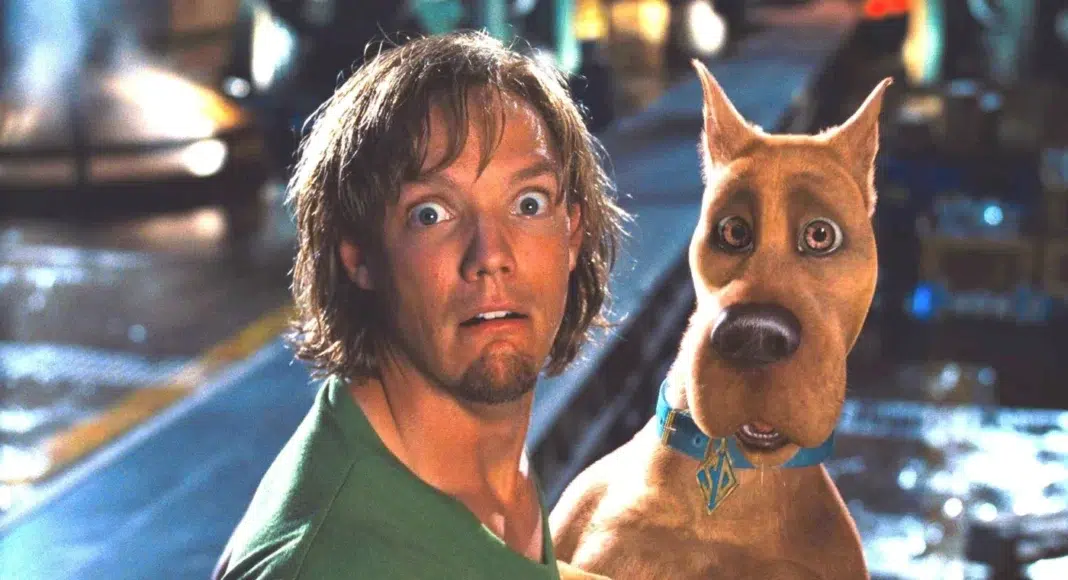 scoobydoo Shaggy from Scooby-Doo with a surprised expression beside Scooby-Doo on a city street at night.