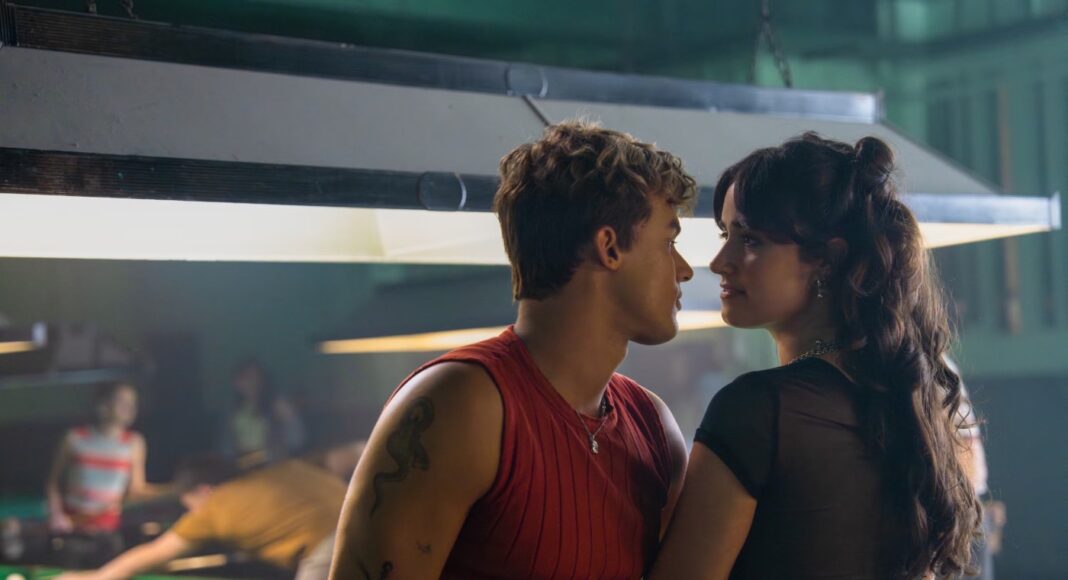sua culpa Couple leaning in for a kiss beside a pool table in a dim billiards hall.