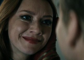Close-up of a woman smiling warmly at someone off-camera.