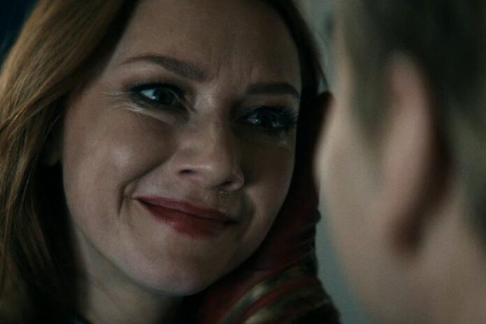 Close-up of a woman smiling warmly at someone off-camera.