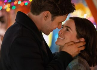 Conheça a nova ROM-COM com Zoey Deutch e Nick Robinson que chegou ao streaming! Couple smiling and embracing, head to head, with colorful festive lights in the background.