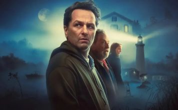 Four adults stand in a misty coastal town at night, with a lighthouse and moonlit sky in the background, suggesting a movie poster.