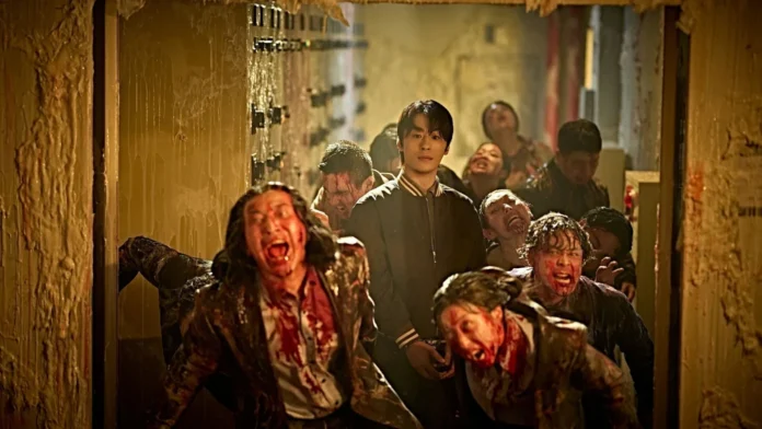 Young man in a black jacket stands calmly in a dim, blood-splattered hallway as snarling, zombified figures swarm around him.