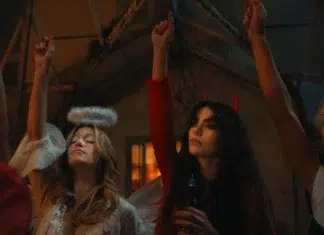 Pânico SATÂNICO se espalha no trailer de ‘O Corpo’, nova série de TERROR da Netflix "Three women in costumes at a party, one dressed as an angel and another as a devil, raising their hands in a dimly lit room with rustic decor, suggesting a festive or Halloween atmosphere."